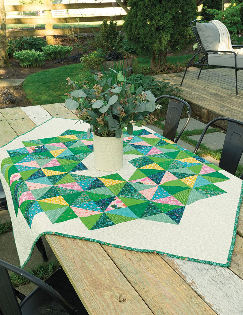 Green patterned quilt laying on a table 