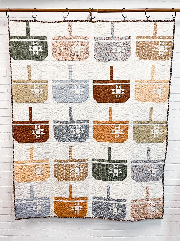 Hanging quilt with assortment of baskets on a white background 