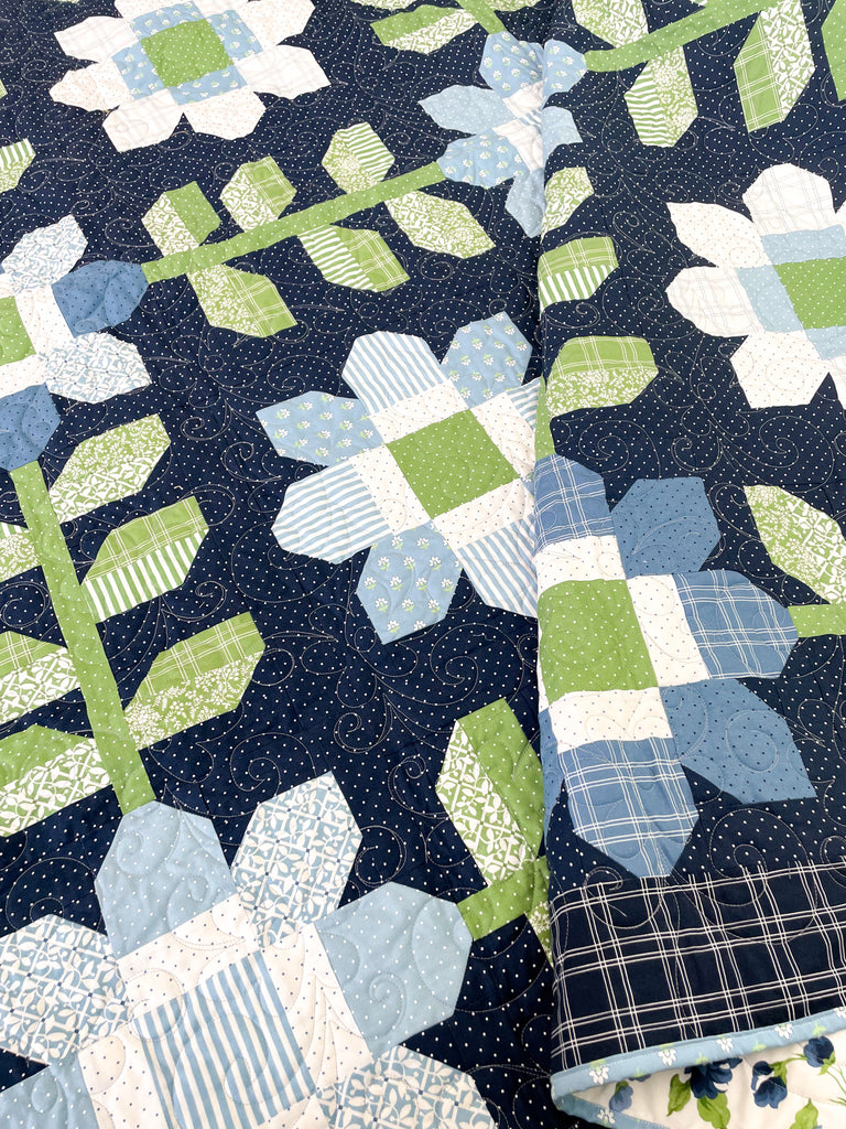 Edelweiss Quilt. Dark blue background with light blue and white flowers 