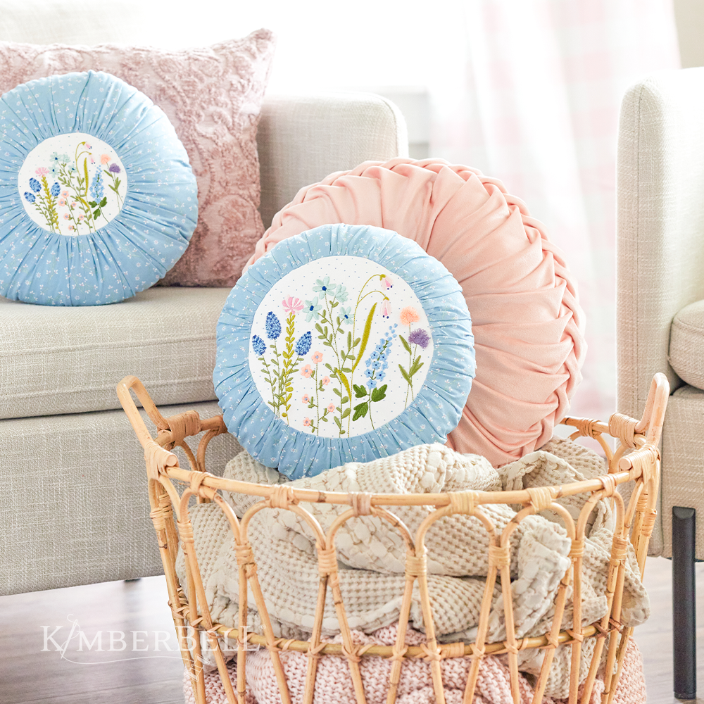 Kimberbell 12" round pillow insert with a cover on it 