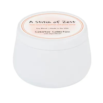 White container with a candle scented "A Stitch of Zest" 